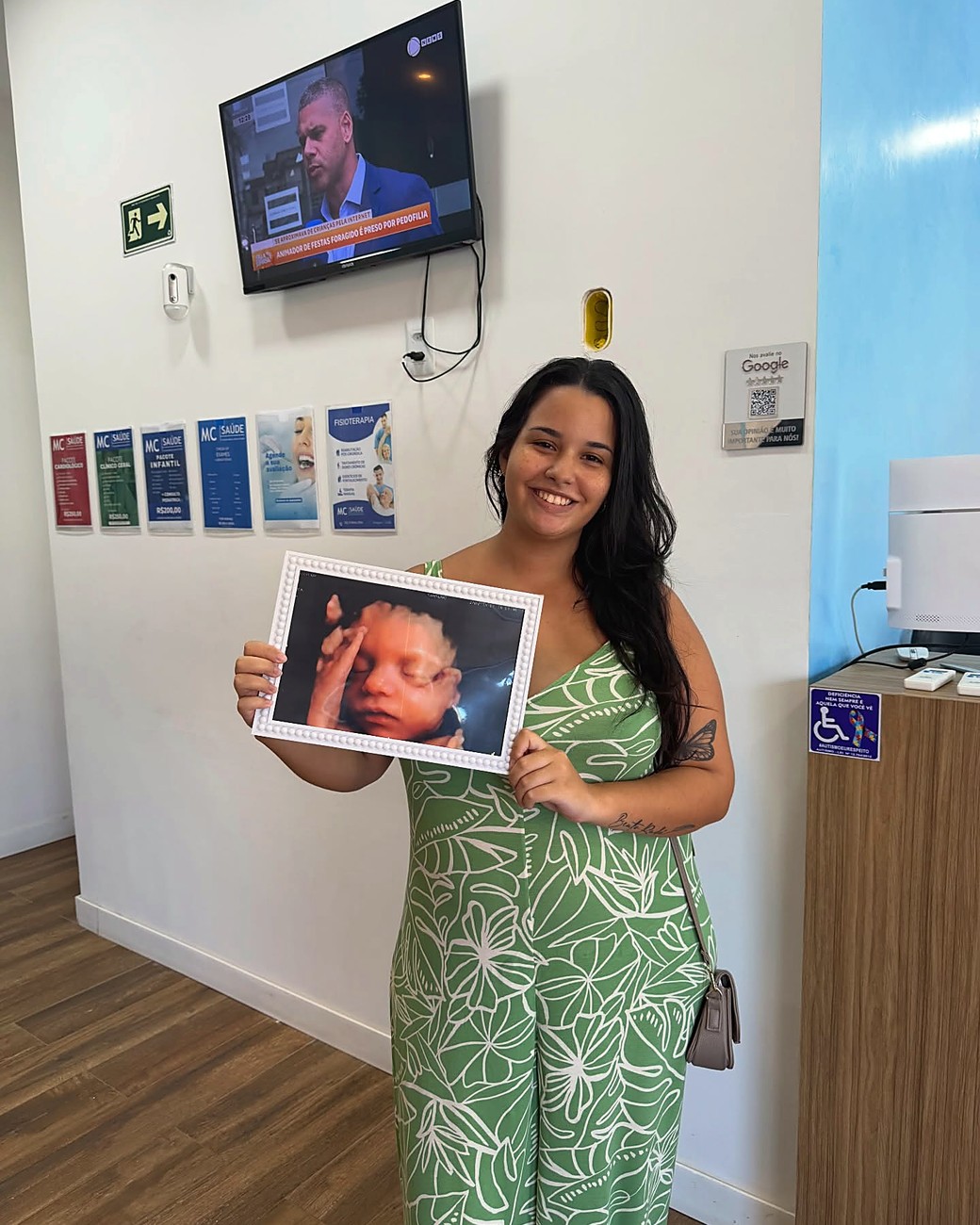 Gestante sorrindo com a foto do ultrassom 3D do bebê
